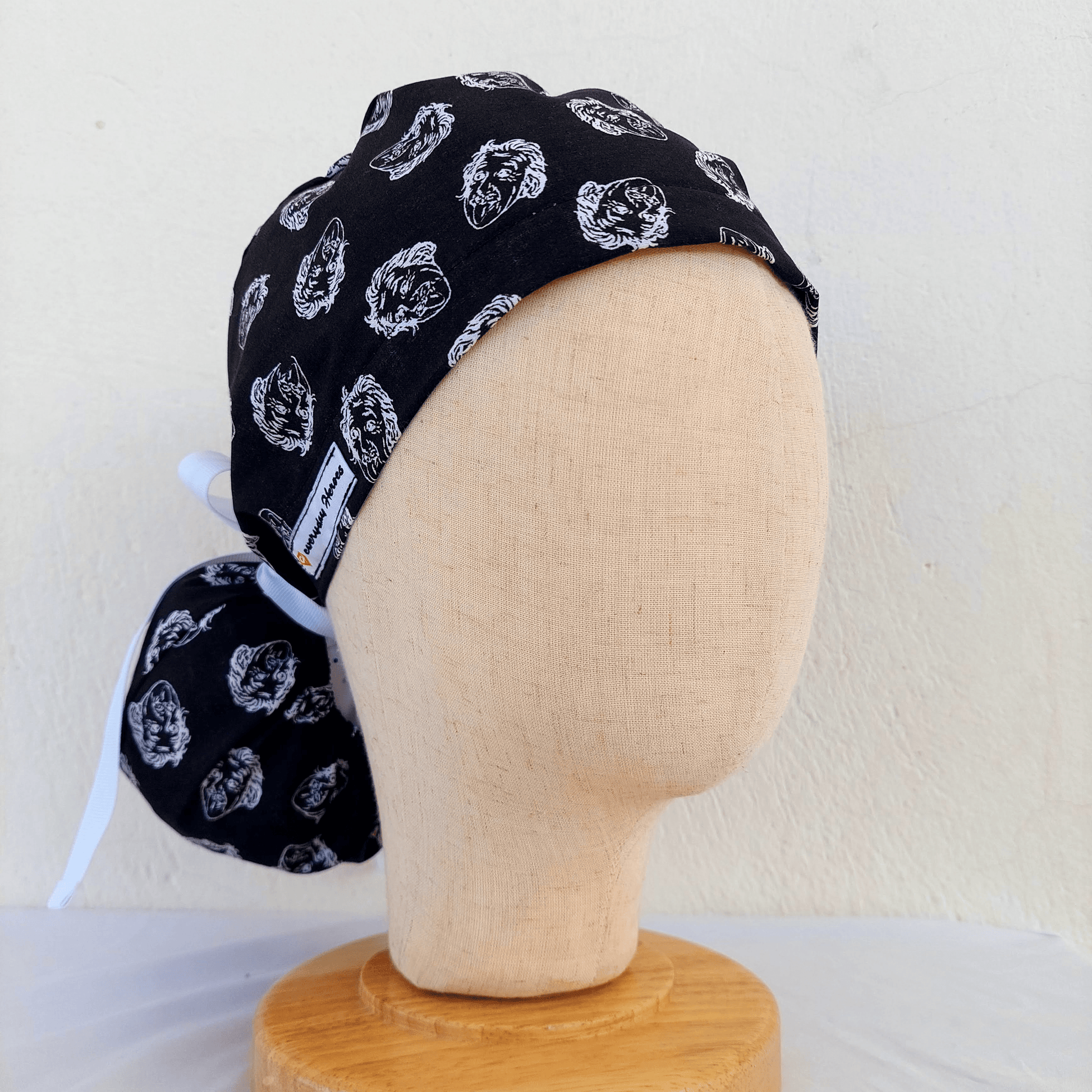 Ponytail scrub cap featuring a playful Einstein face print, designed with adjustable ribbon ties and an absorbent sweatband. Perfect for nurses, surgeons, and doctors who want comfort and personality in the operating room.