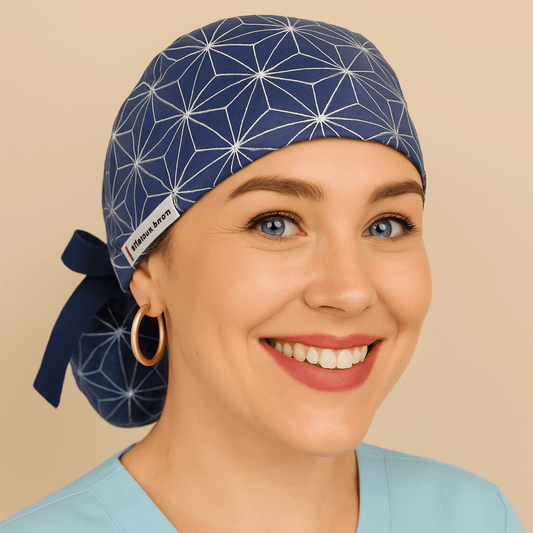 Navy Blue scrub cap with geometric starburst tie back style, and Everyday Heroes label. Modeled by a smiling woman in a light blue scrub top with gold hoop earrings, this surgical hat is ideal for nurses, doctors, and surgeons. Comfortable ponytail scrub cap, reusable and washable, perfect for medical, dental, or hospital staff.