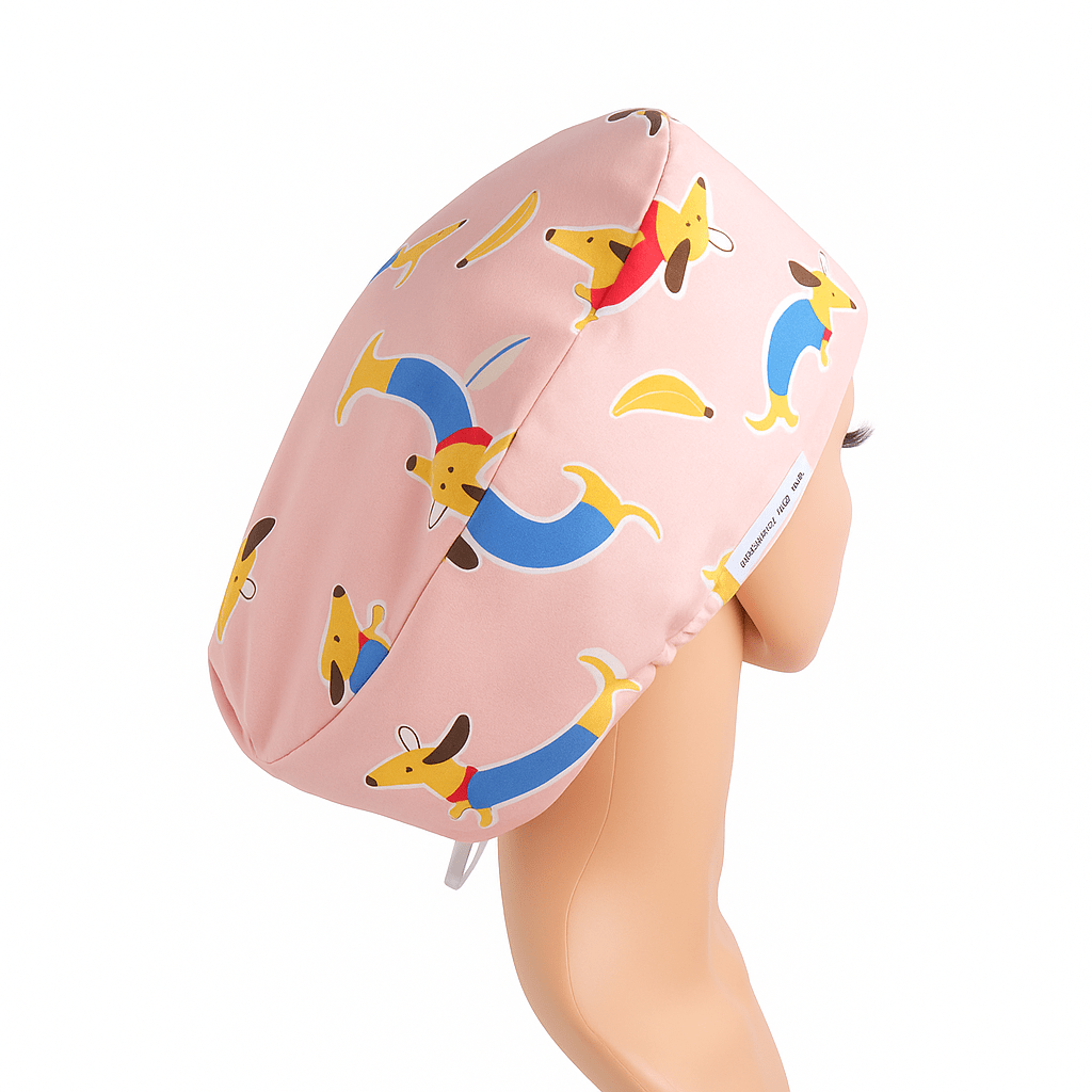 Custom Doxie dachshund vet scrub cap for women, shown on a mannequin head, featuring a playful weenie dog and sausage dog print in pink tones. This euro-style scrub cap is designed for animal surgeons and veterinary professionals. Optional satin lining adds comfort, with additional customization available including buttons for mask support and personalized embroidery. A fun and functional surgical scrub hat with ponytail space.