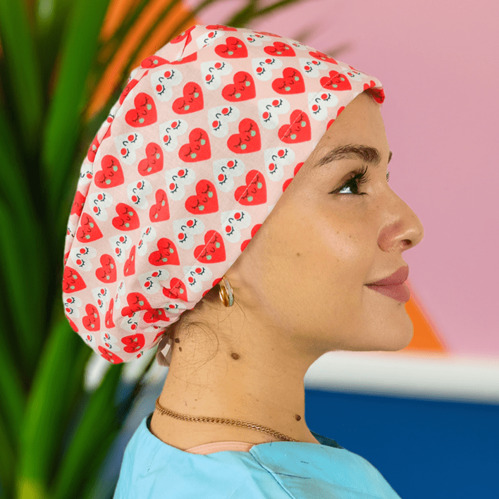 a nurse wearing a custom scrub cap with red hearts on a cotton print and can add satin inside or her name on it