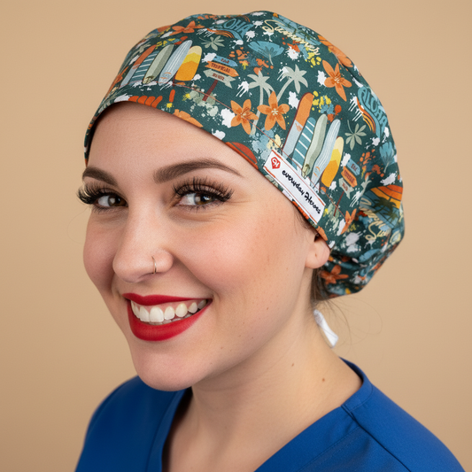 Woman in 3/4 angle looking at camera wearing dark teal Aloha Hawaii scrub cap - tropical pattern with surfboards, palm trees, orange flowers and rainbows - euro style surgical hat with everydayheroescaps label - professional medical headwear for beach-loving nurses and healthcare workers
