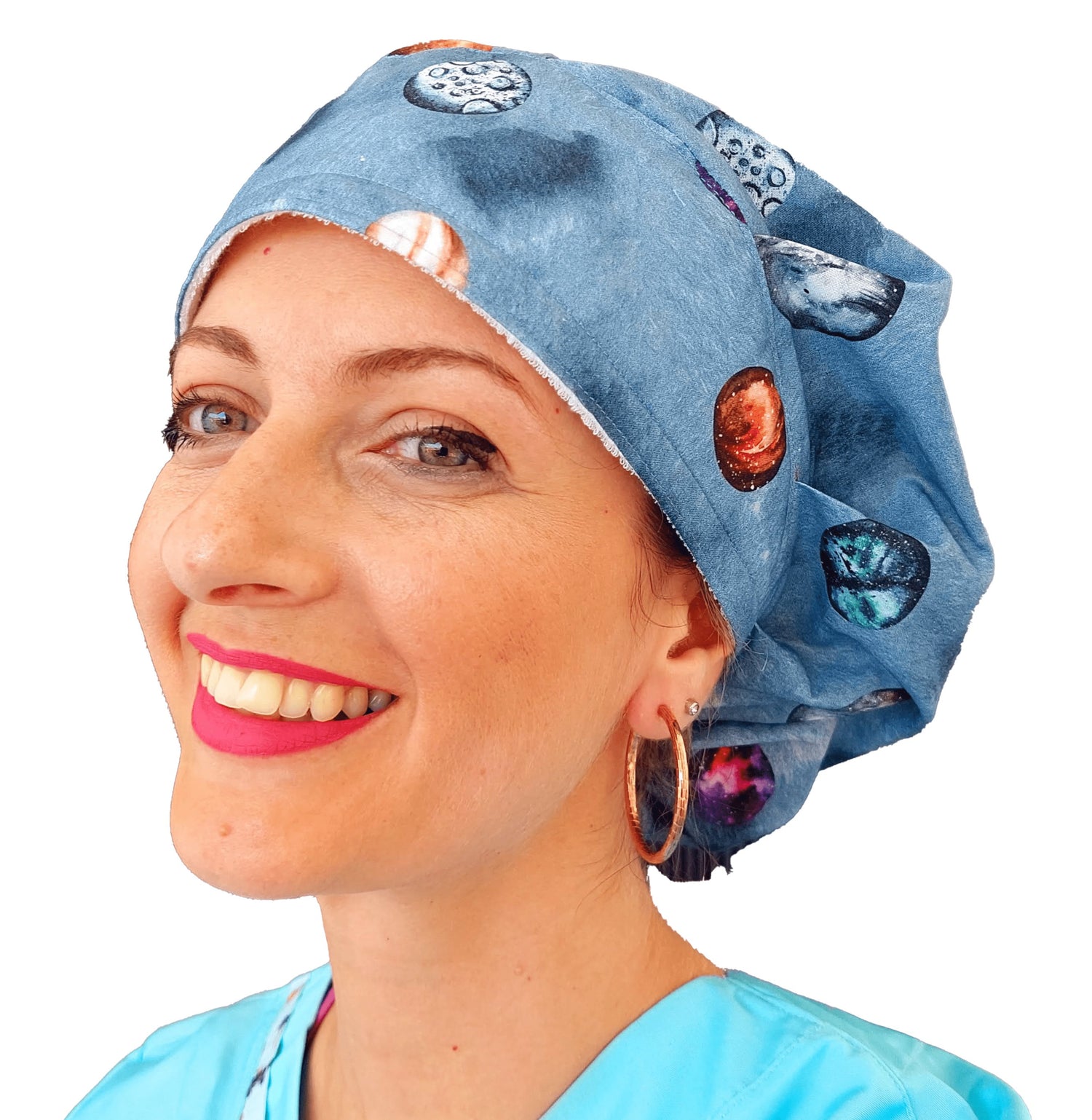 A cute nurse smilling wearing a colorful scrub cap bouffant style with planets print . 