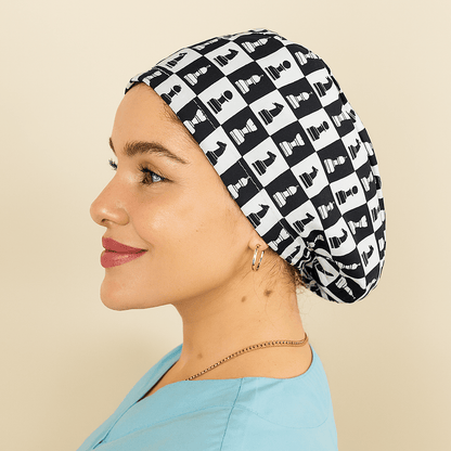 A woman wearing a black and white patterned cap with a light blue top.