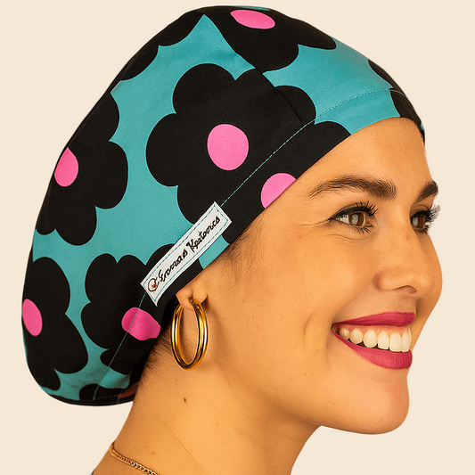 A woman wearing a blue and black floral patterned cap with pink polka dots, smiling and looking to the side.