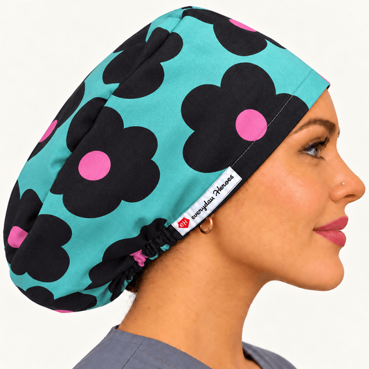 A side-profile portrait of a woman wearing a teal scrub cap with a bold black flower pattern and pink centers. 