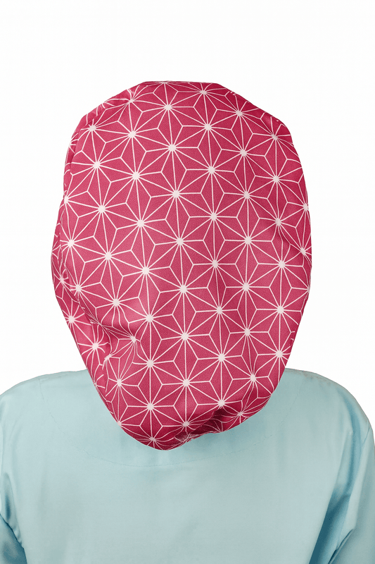 a woman wearing  apink scrub cap with abstract asanoha cotton print, the style is euro scrub hat its adjustable and she is smilling .