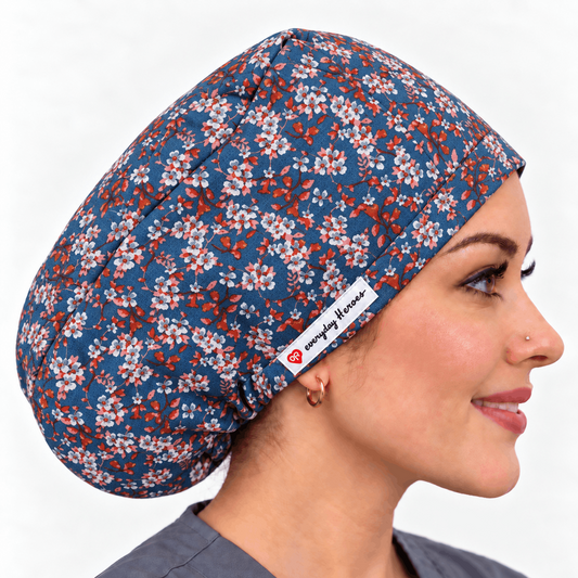 A woman in profile wearing a blue scrub cap with a white and orange floral pattern.