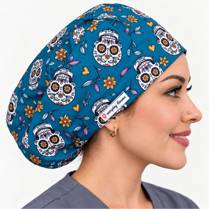 A woman in profile wearing a teal scrub cap with a sugar skull and floral pattern. The scrub cap features a white brand label that reads 'Daily Gown' with a heart logo.
