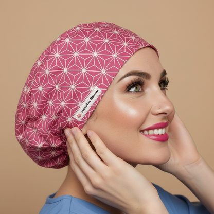 Sophisticated abstract scrub cap back side view with smiling healthcare professional - berry pink raspberry bouffant euro custom surgical cap featuring white geometric star pattern - satin lined OR anatomy nurse cap for women with adjustable fit - name personalized embroidery option - woman with hot pink lipstick green hazel eyes showing confident smile - Everyday Heroes brand label visible - professional medical headwear - asanoha Japanese geometric design - adjustable elastic fit for nurses doctors
