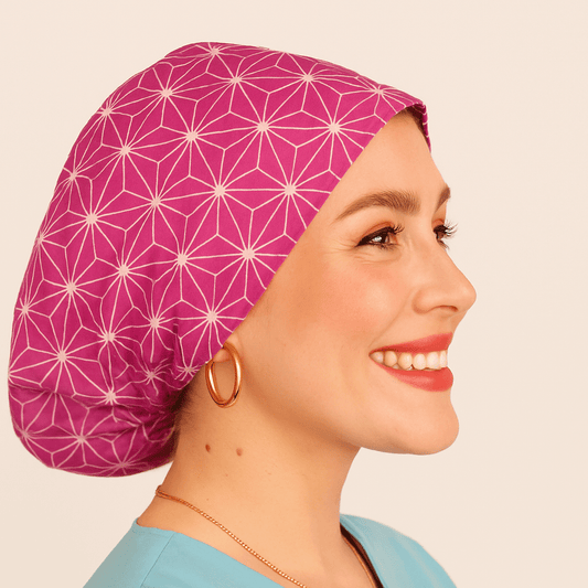 Smiling woman wearing a fuchsia Japanese Asanoha pattern euro scrub cap. Satin-lined and adjustable for comfort, this custom surgical hat is ideal for nurses, theatre staff, and medical professionals. Personalized with name embroidery for a unique touch.