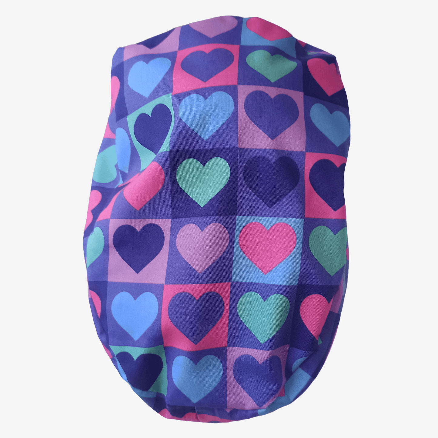 Beautiful brunette healthcare worker wearing purple and pink hearts pattern bouffant scrub cap with Everyday Heroes label, smiling in three-quarter view against white background. Premium medical scrub hat with colorful heart print design, adjustable fit, professional nursing cap for women. High-quality surgical cap with satin lining, handmade in Greece, perfect for nurses, doctors, and medical professionals.
