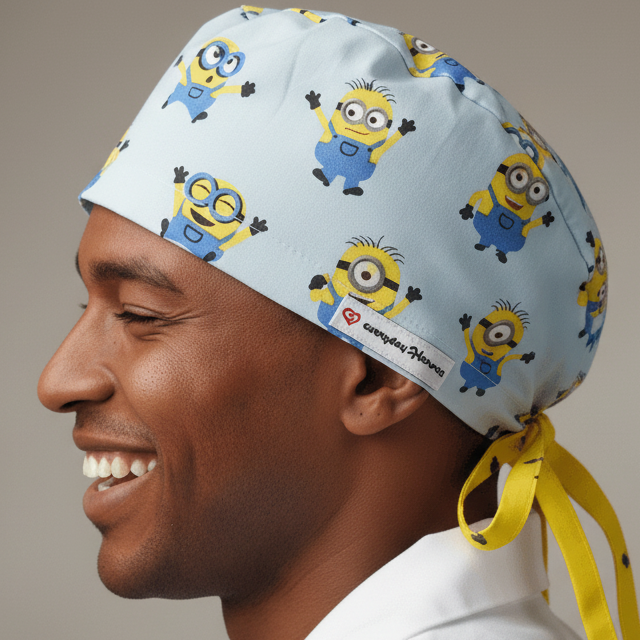 Funny Men's Surgeon Cap featuring Minions cartoon characters on light blue fabric. Comic Characters Custom Scrub Cap with Name personalization option, shown on white mannequin side view with Everyday Heroes label. Doctors Personalized Gift Surgical Cap With Name embroidery available. Adjustable bouffant euro style medical headwear for healthcare professionals. Minion scrub cap in blue 