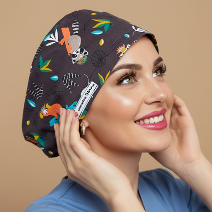 Playful King Julien Madagascar scrub cap back side view with smiling healthcare professional - fun lemur design featuring orange coral lemurs white gray lemurs with striped tails on dark gray - perfect for nurses who love Madagascar movies bringing smiles to patients - euro scrub hat customizable with name personalization - adjustable toggle soft sweatband forehead comfortable all-day wear - woman with hot pink lipstick green hazel eyes - Everyday Heroes brand visible - jungle animal pattern