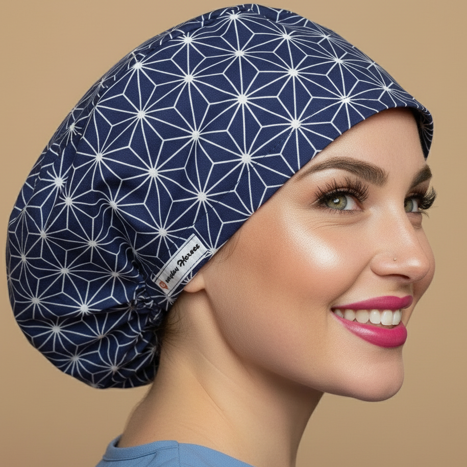 Navy blue geometric scrub cap back side view looking at camera with smiling healthcare professional - Japanese asanoha pattern featuring white geometric star shapes hexagons on dark blue background - euro style bouffant surgical cap for women - custom satin lined with name embroidery option - adjustable elastic fit - woman with hot pink lipstick green hazel eyes showing confident smile - Everyday Heroes brand label vi