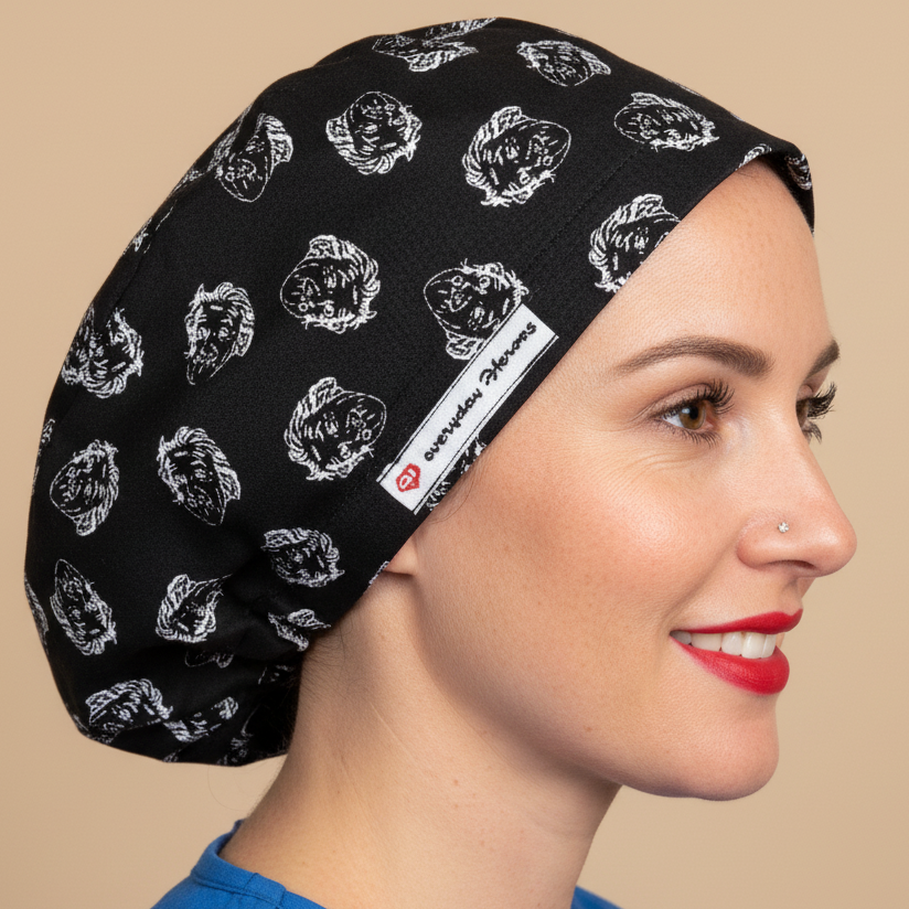 Woman wearing black scrub cap with Einstein face pattern in profile view - euro style surgical hat with white sketched Einstein portraits on black fabric - satin lining and everydayheroescaps label - professional medical headwear for nurses, doctors and science lovers
