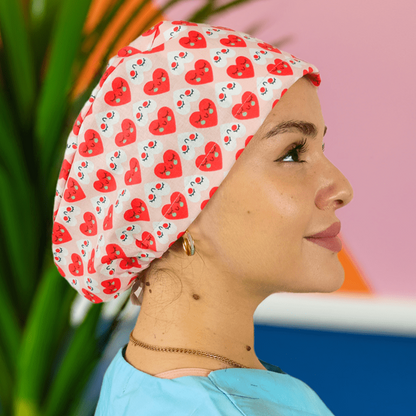 a nurse wearing a custom scrub cap with red hearts on a cotton print and can add satin inside or her name on it
