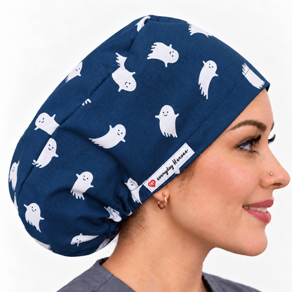 A woman in profile wearing a navy blue scrub cap with a white ghost pattern. is 