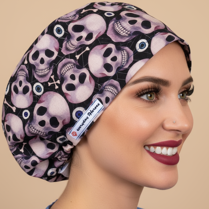Woman in blue scrubs wearing pink and purple skulls euro scrub cap - left profile showing realistic skull pattern surgical hat with satin lining option for nurses, doctors, vets