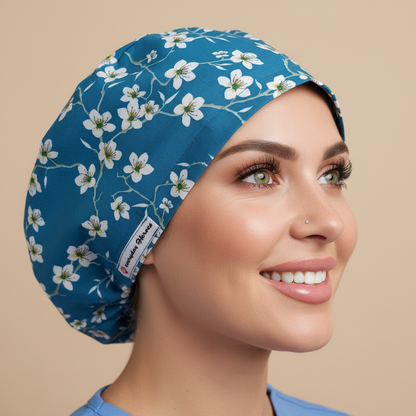 Almond blossom medical scrub hat with white flowers on teal blue - woman wearing euro style bouffant surgical cap with custom satin lining and name embroidery option - professional scrub caps for nurses doctors OR staff - Everyday Heroes brand
