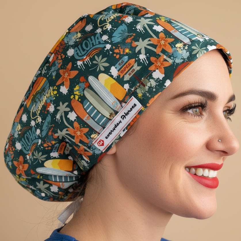 Woman in 3/4 angle looking at camera wearing dark teal Aloha Hawaii scrub cap - tropical pattern with surfboards, palm trees, orange flowers and rainbows - euro style surgical hat with everydayheroescaps label - professional medical headwear for beach-loving nurses and healthcare workers
